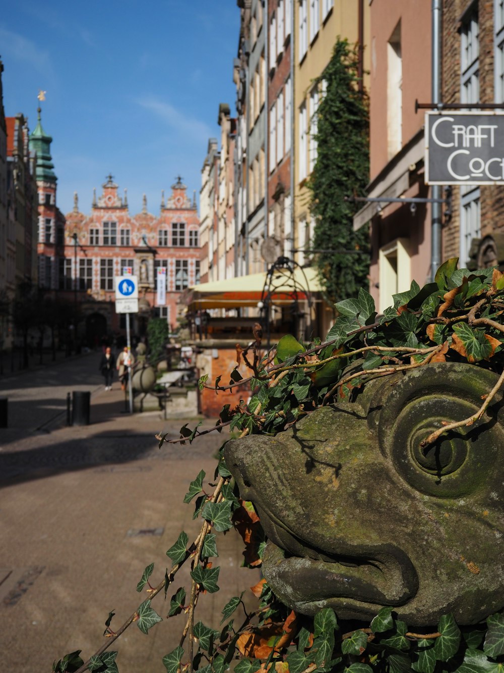 a statue of a frog on a city street