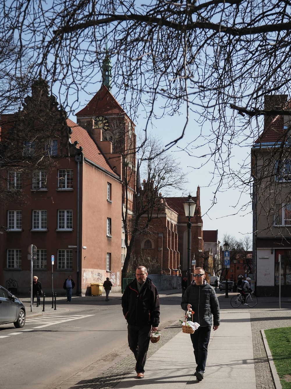 a couple of men walking down a street next to tall buildings