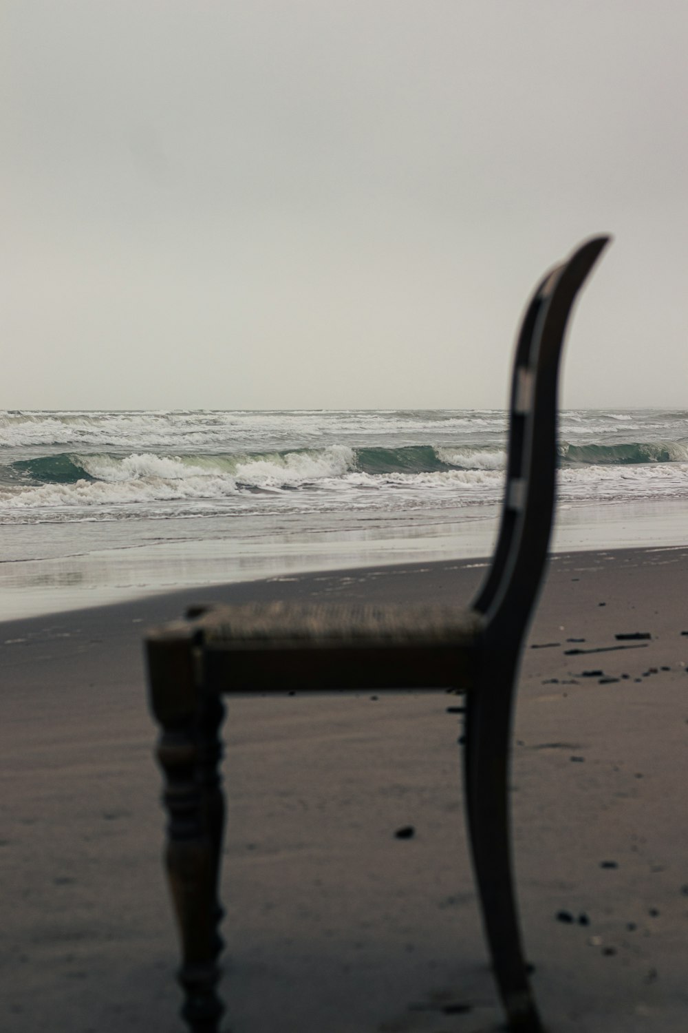 a bench sitting on top of a beach next to the ocean