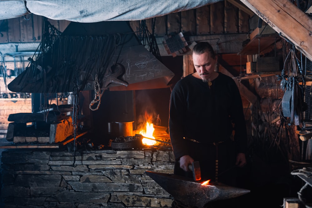 a man standing next to a fire in a fireplace