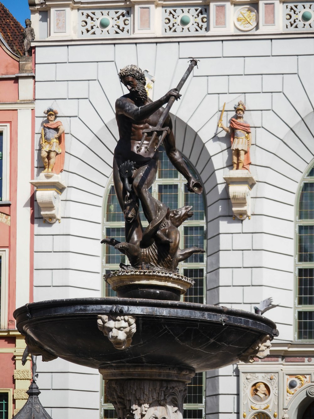 a statue of a man holding a sword on top of a fountain