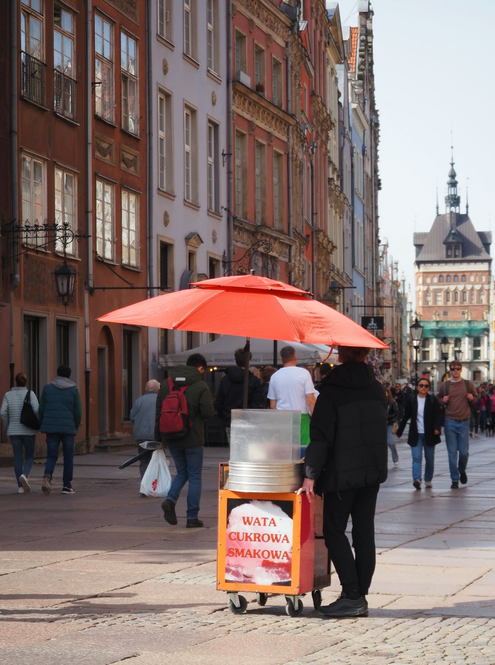 uma pessoa com um guarda-chuva vermelho em uma rua da cidade