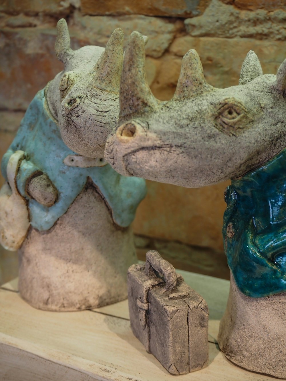 a couple of statues of rhinos on a shelf