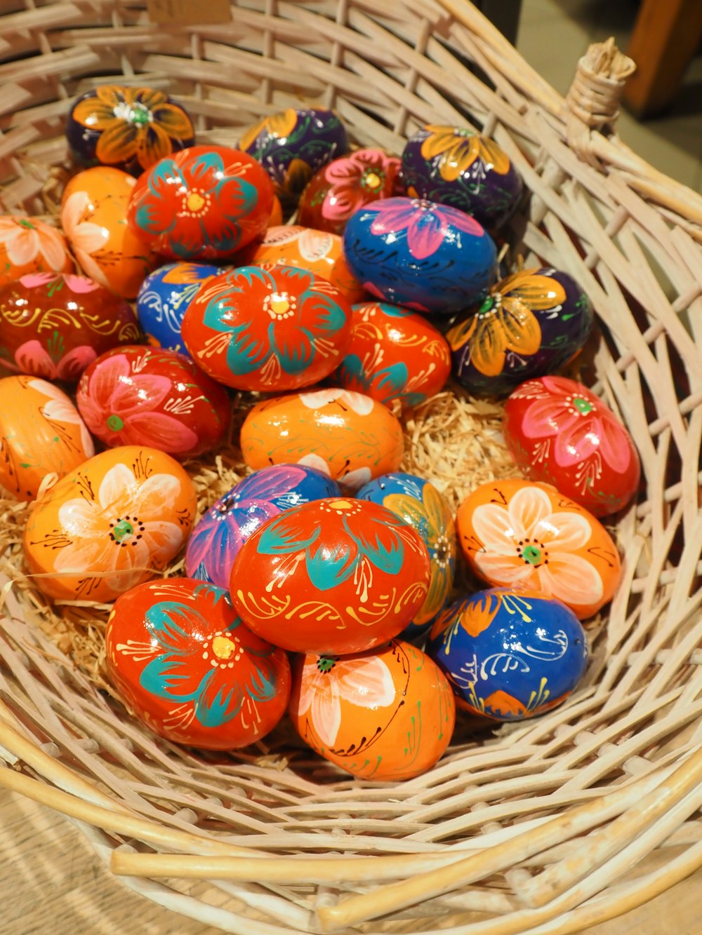 a basket filled with lots of colorful painted eggs