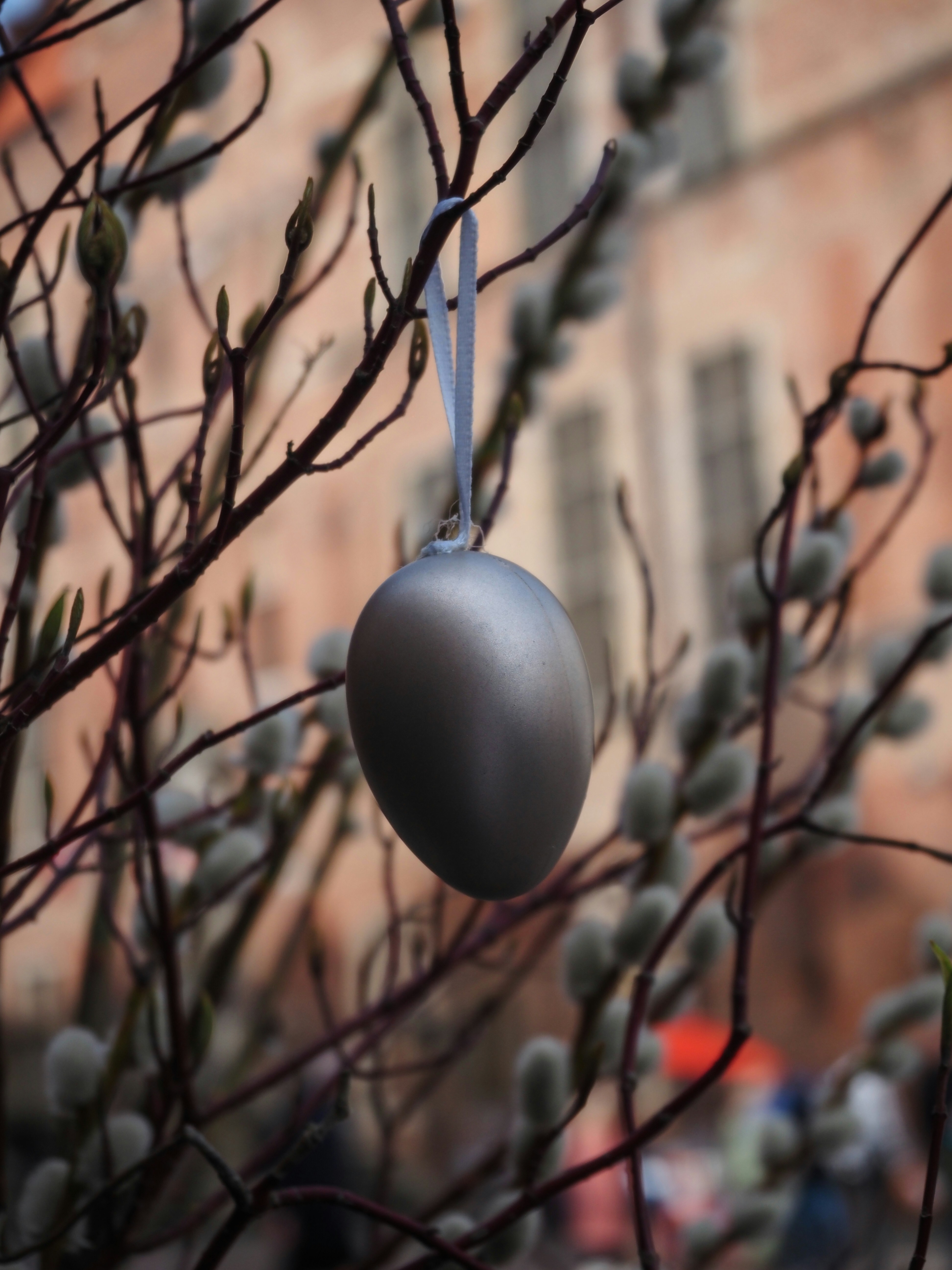 un adorno de plata que cuelga de la rama de un árbol