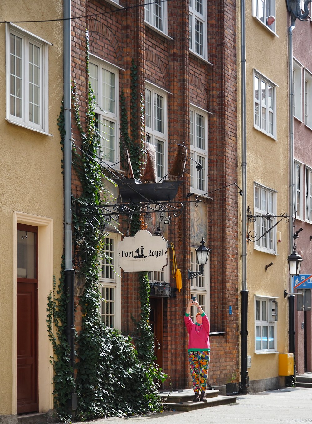 a woman standing in front of a tall brick building