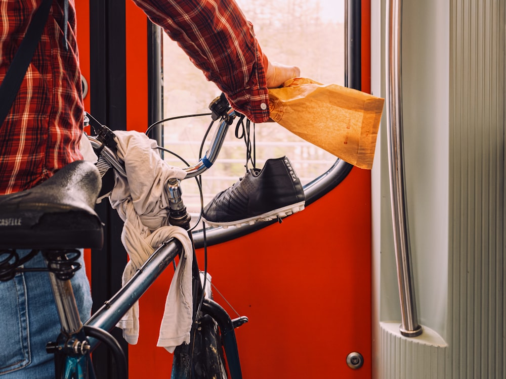 a man standing next to a bicycle holding a bag