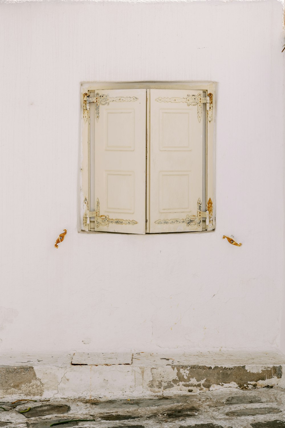 a white wall with a window and a bench in front of it