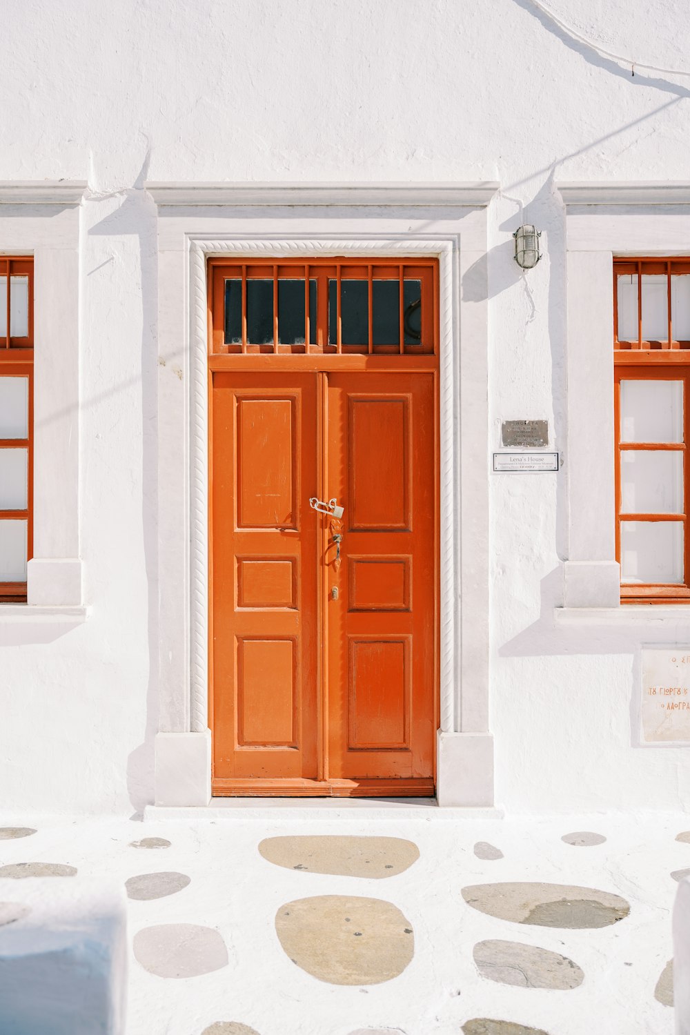 a white building with a red door and two windows