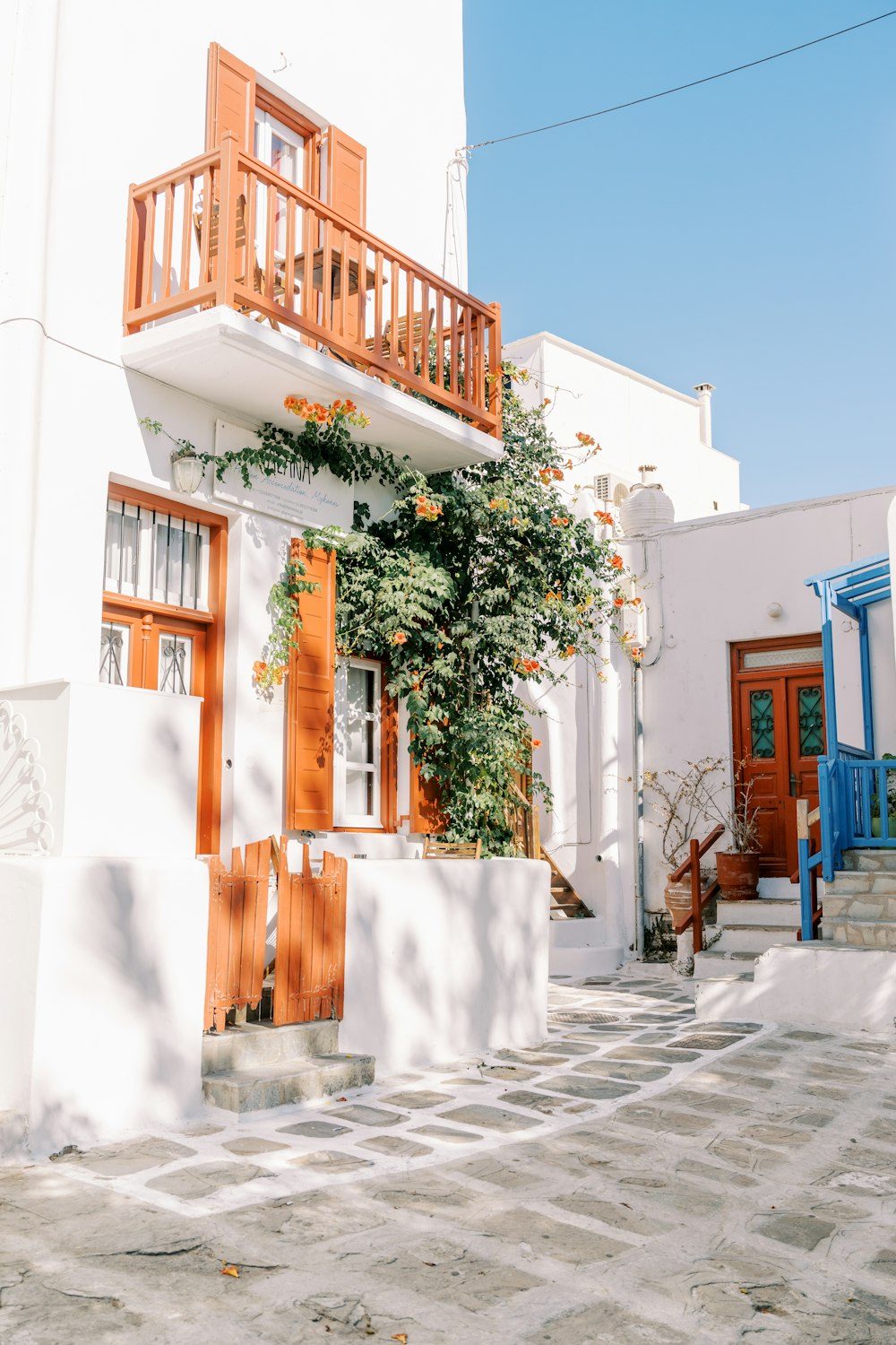 a white building with wooden doors and a balcony