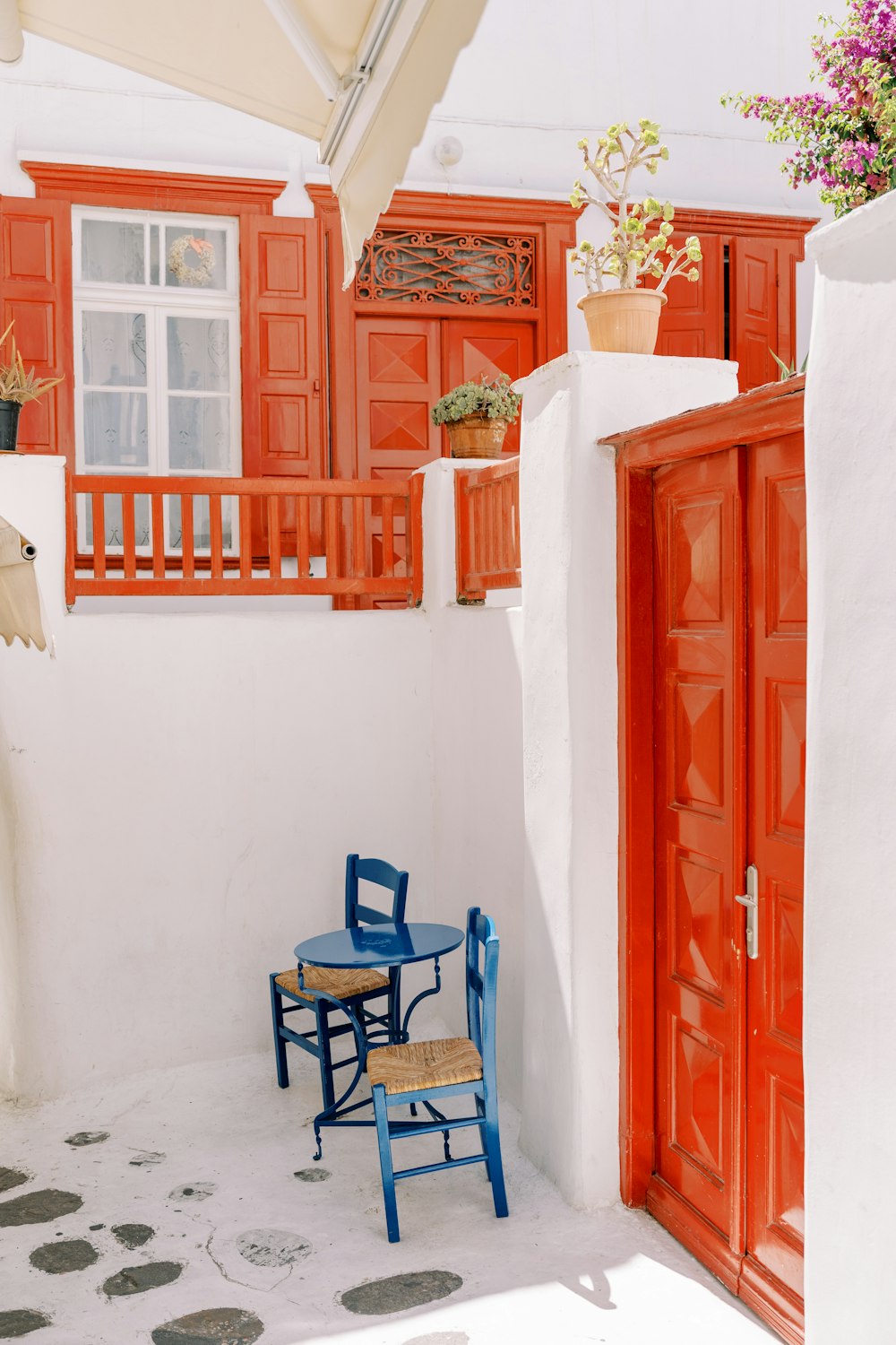 a blue chair and a blue table in front of a red door