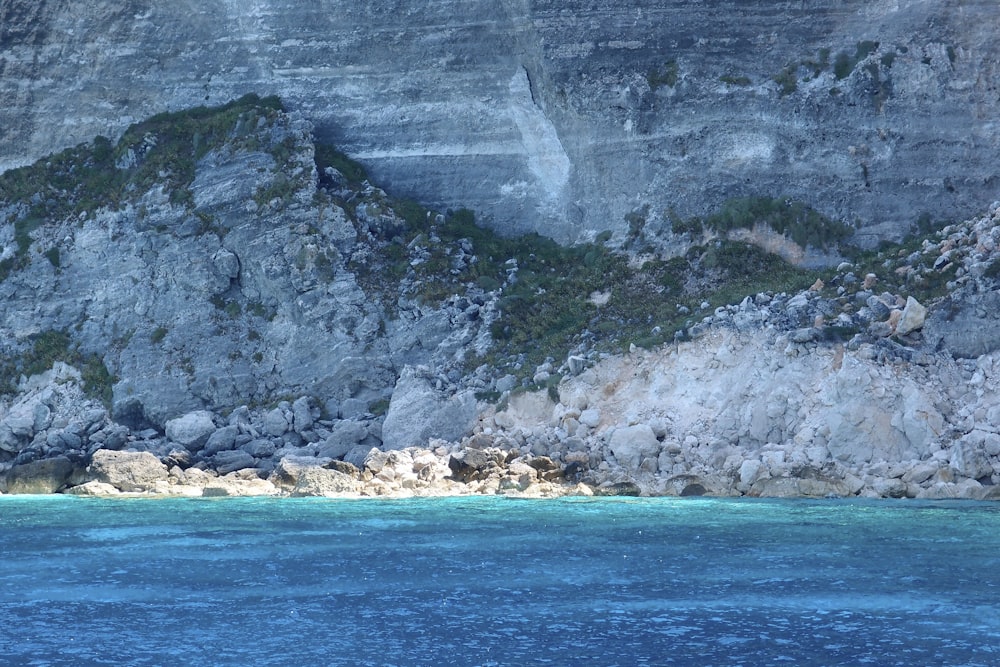 a boat is in the water near a mountain