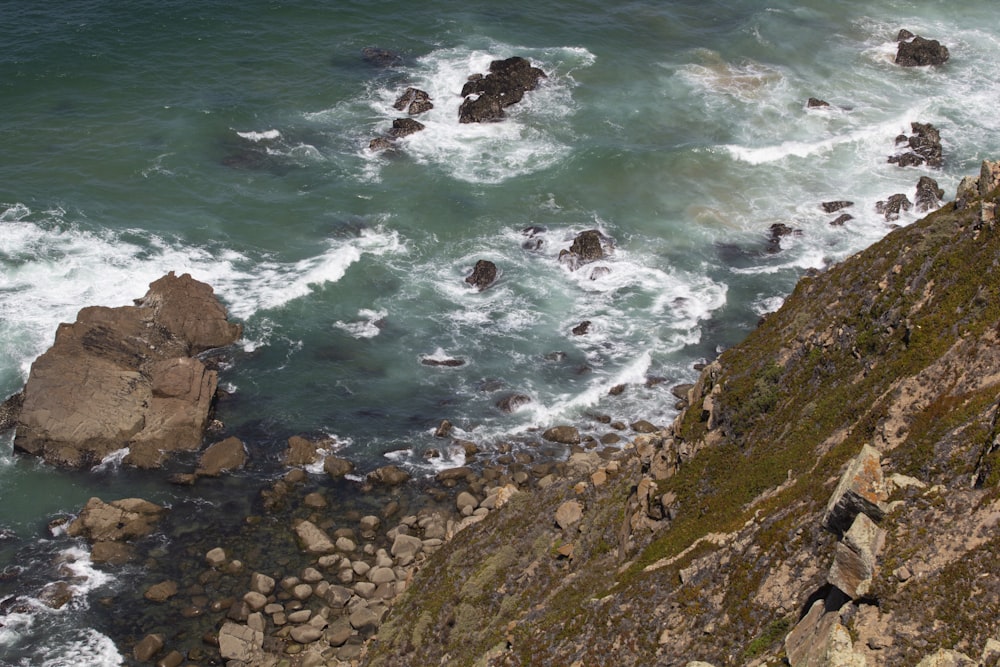 an aerial view of the ocean and rocks