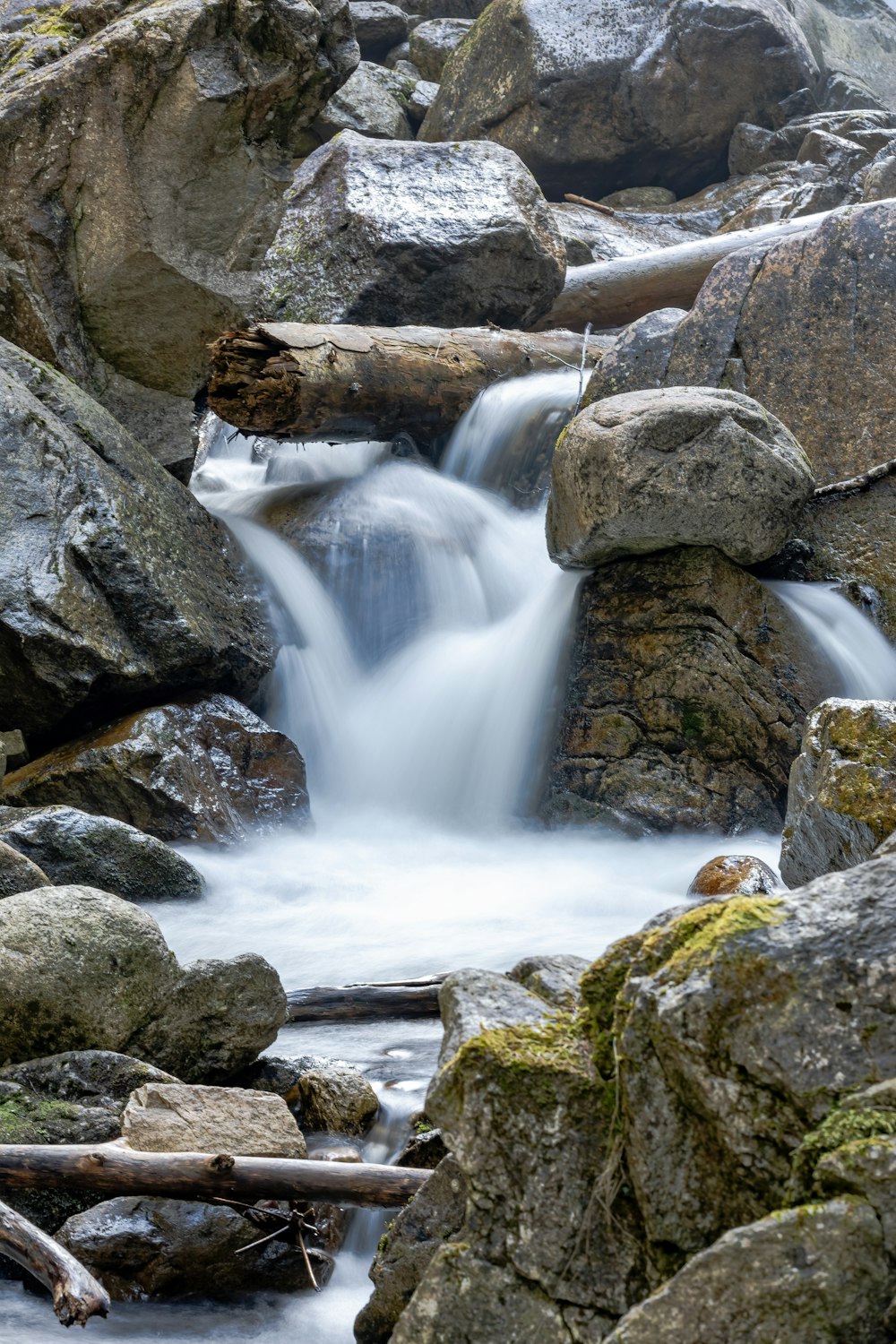 a stream of water running over rocks in a forest