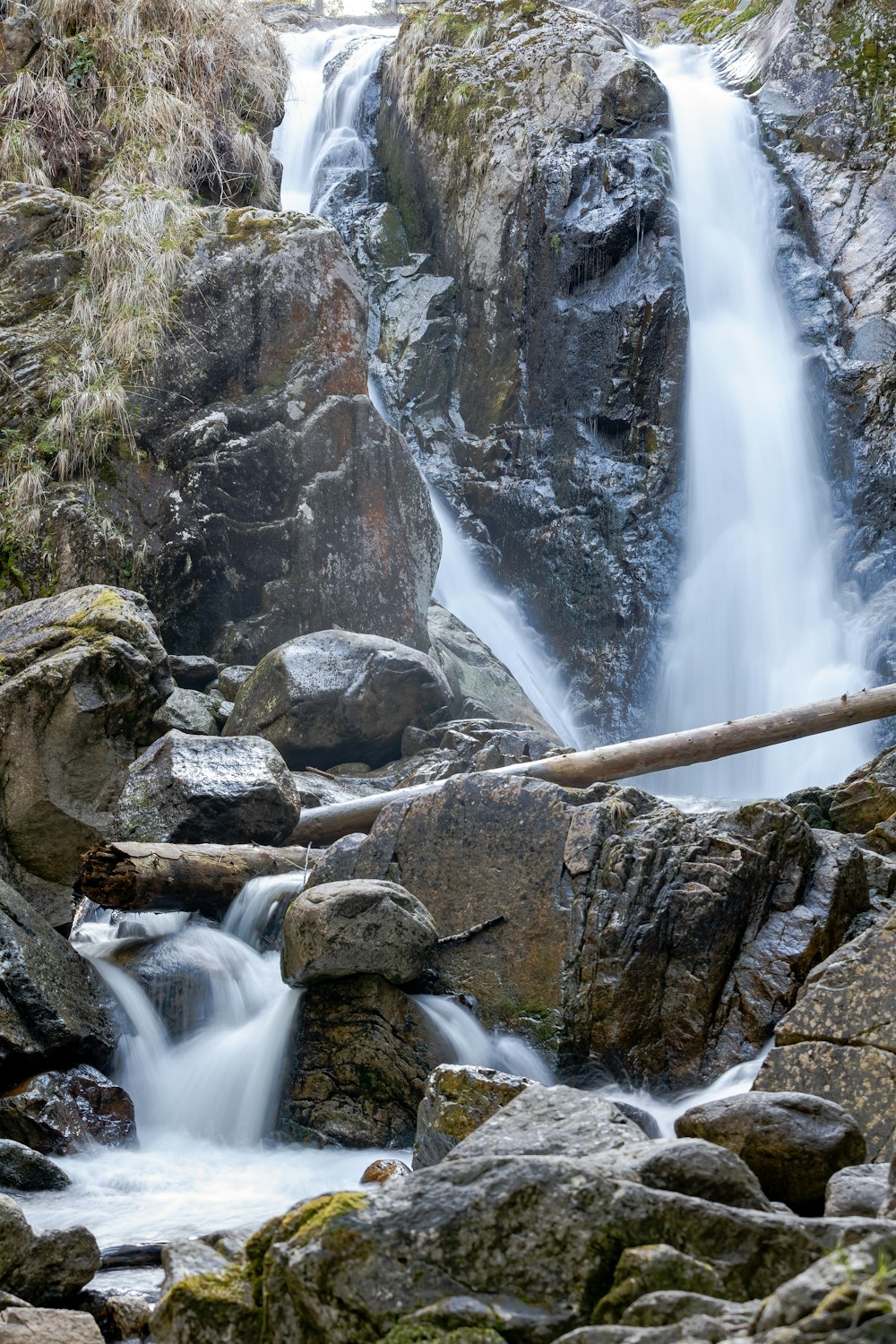 a large waterfall with a wooden bridge over it
