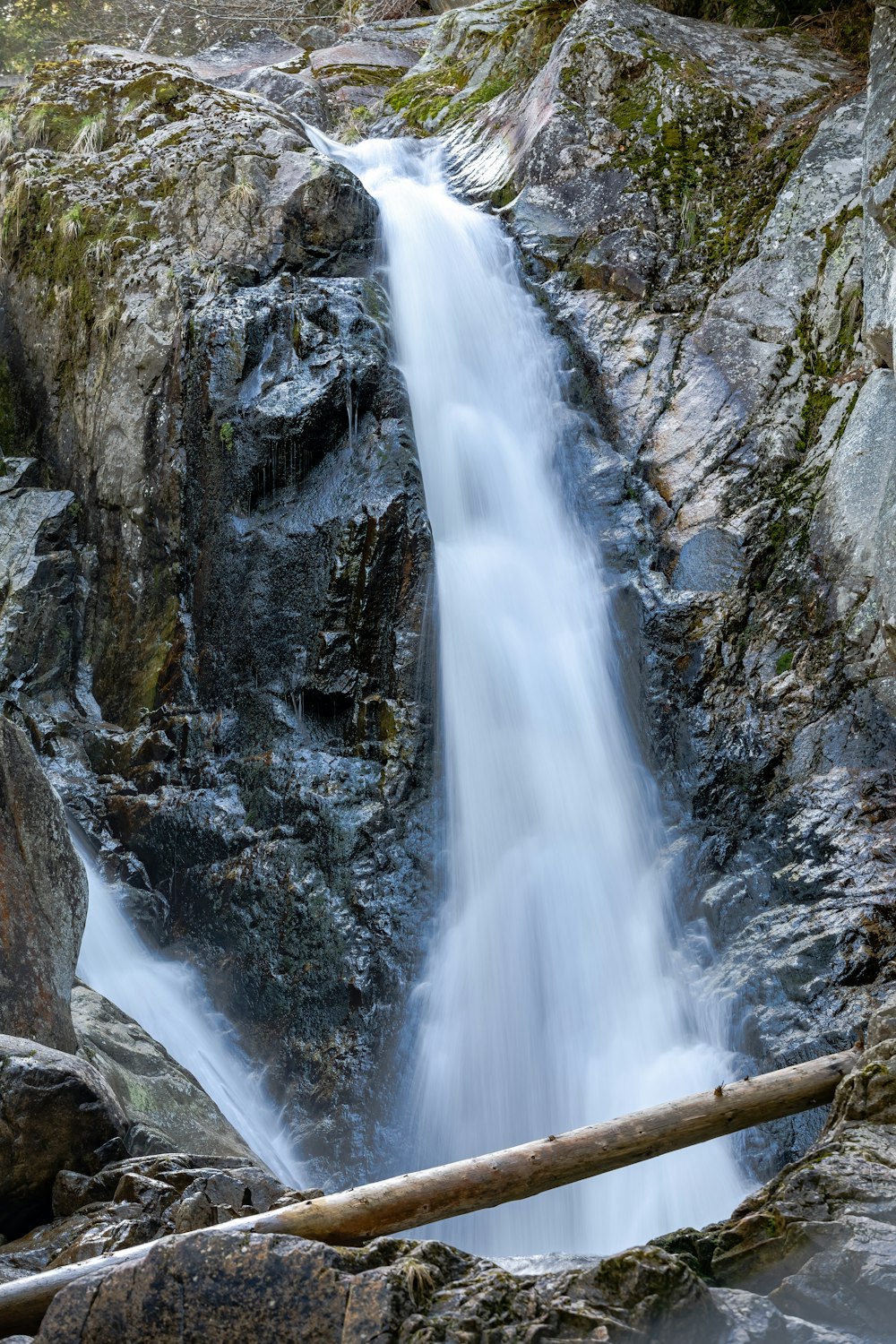 a small waterfall is flowing down a rocky mountain