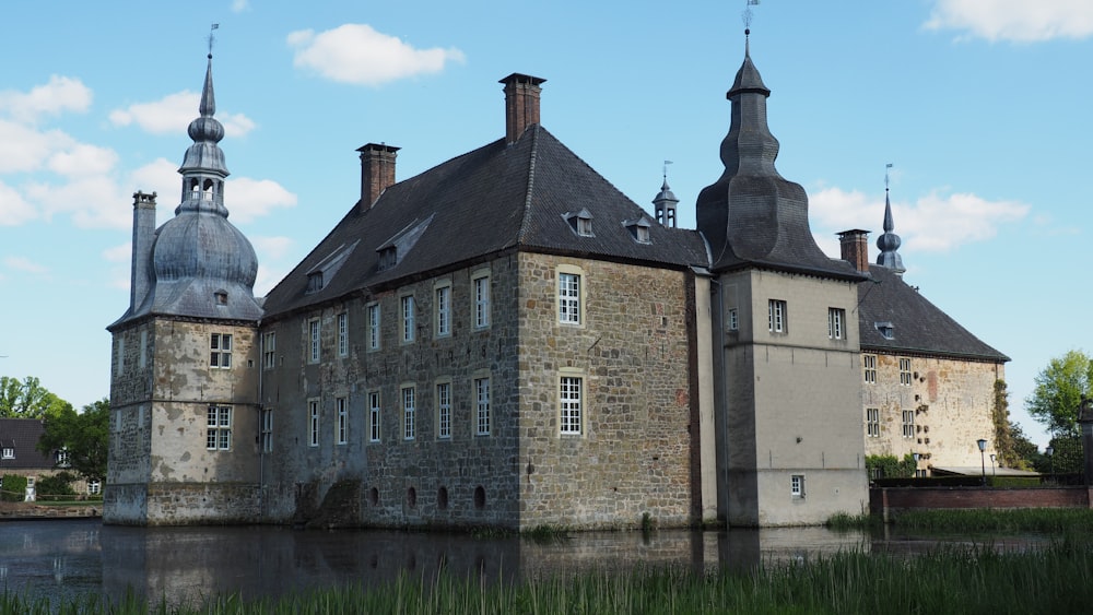 a large building with two towers next to a body of water