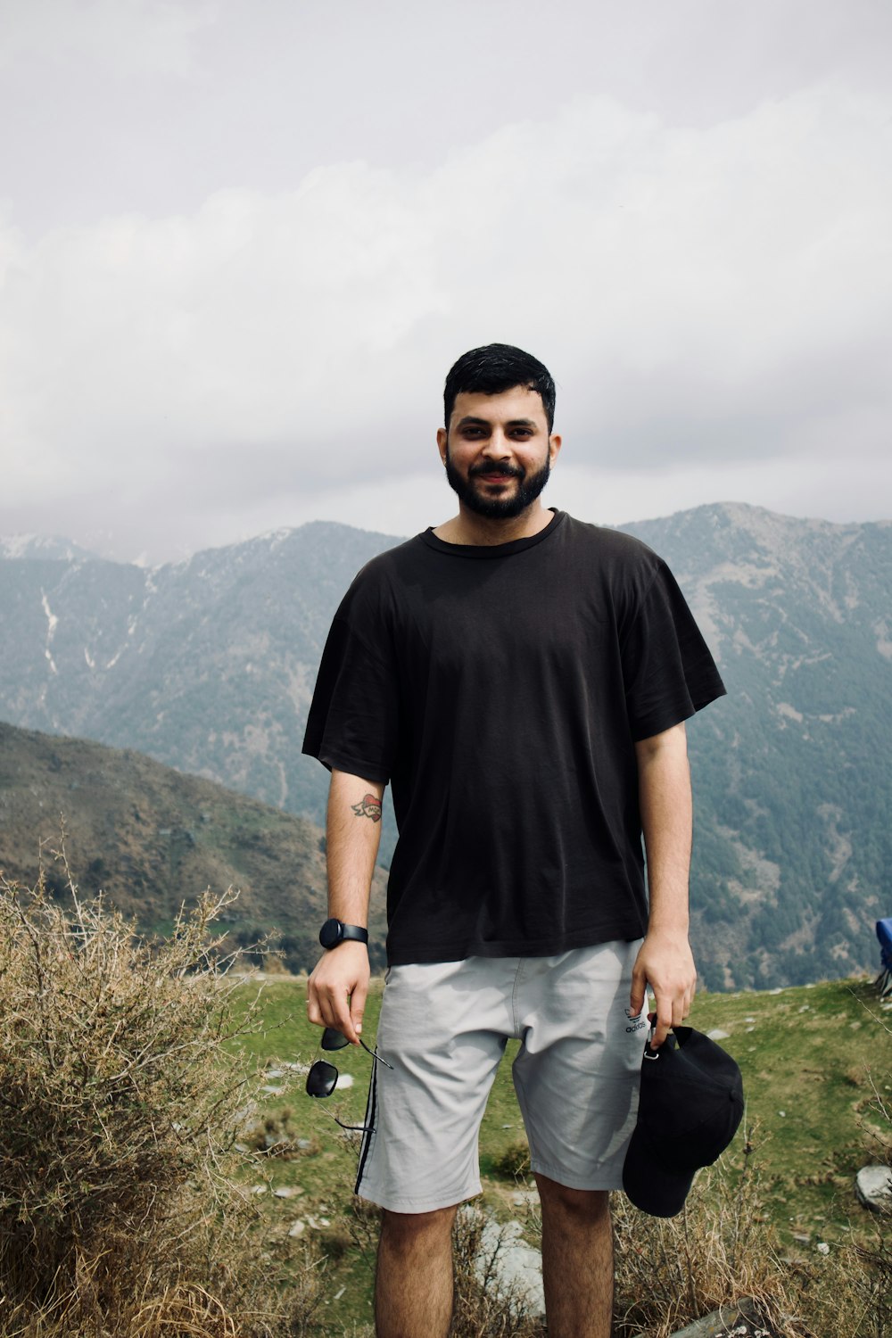 a man standing on top of a grass covered hillside