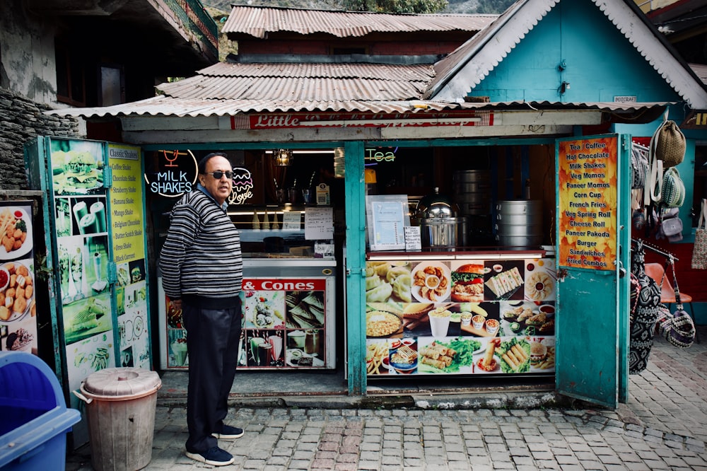 a man standing in front of a food stand