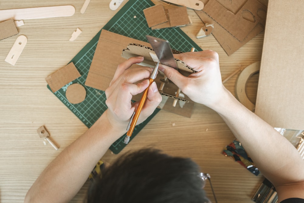 a person working on a craft project on a table