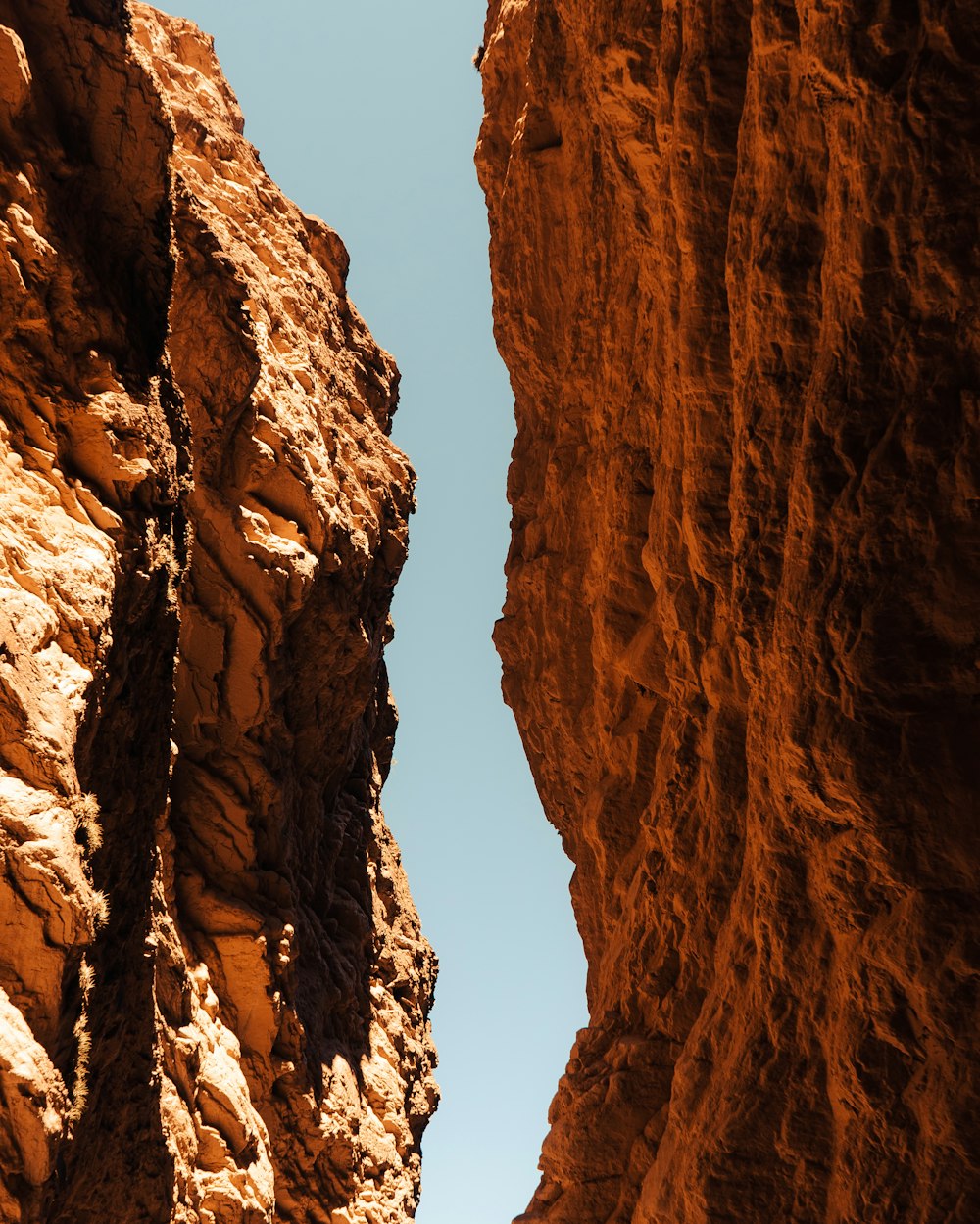 a person standing in a canyon between two large rocks