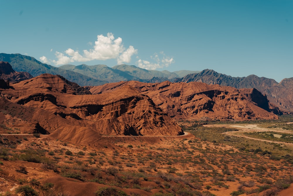 a scenic view of a desert with mountains in the background