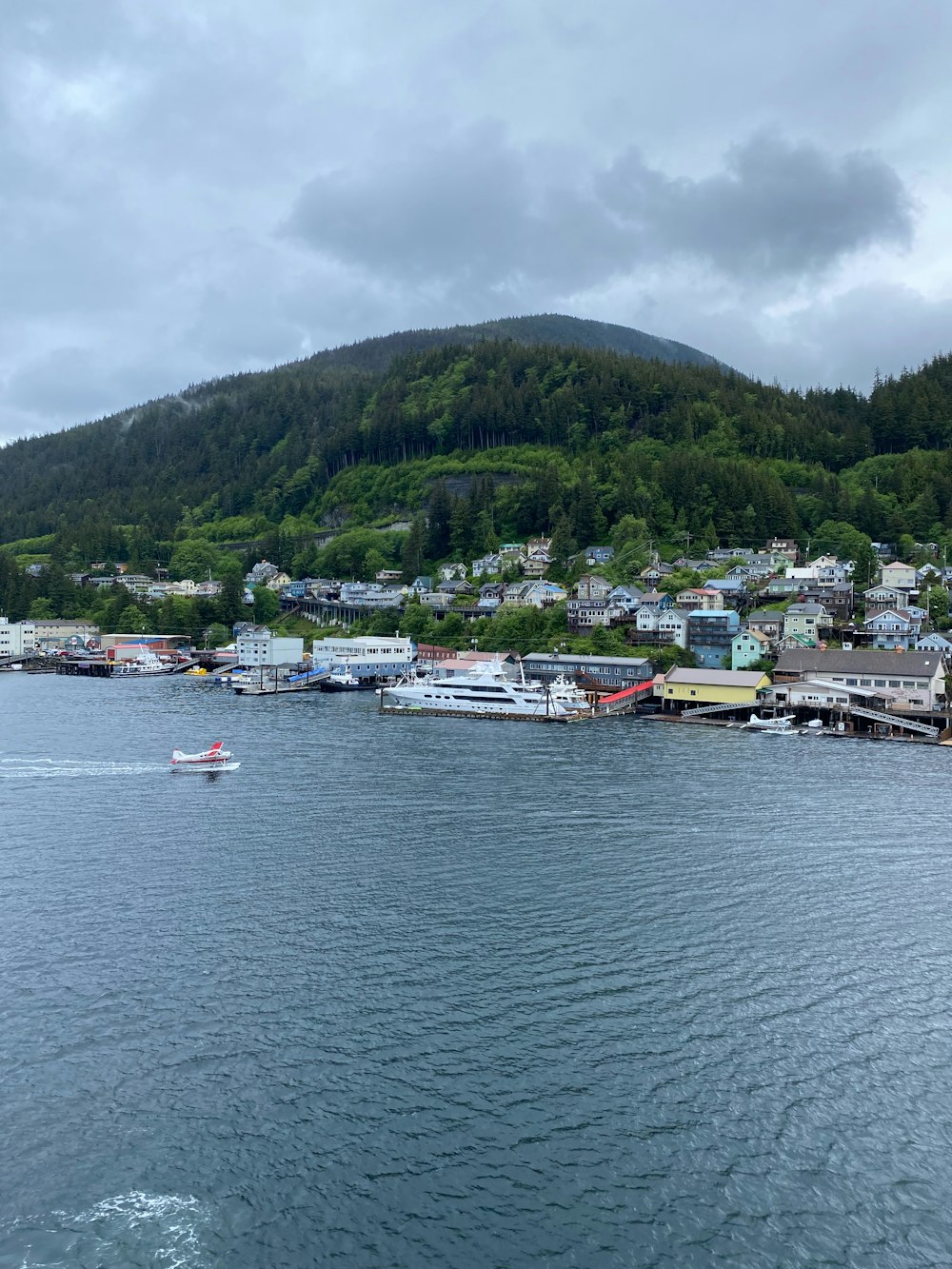 a body of water with houses on a hill in the background