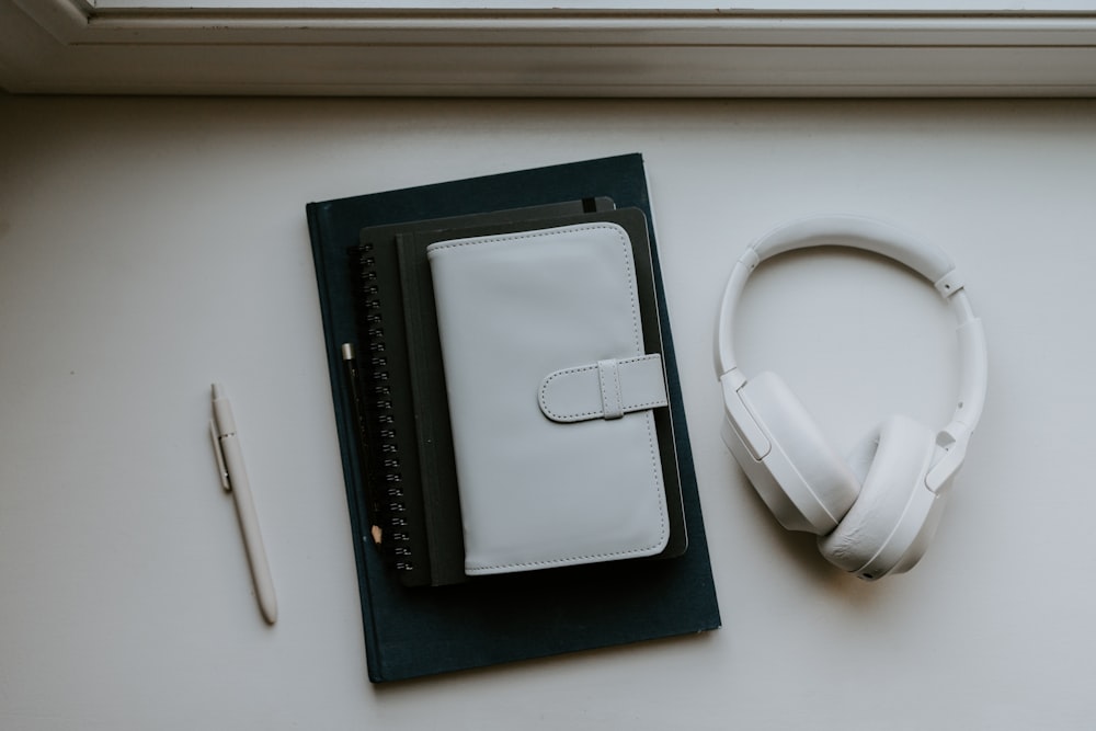 a book, headphones, and pen on a table