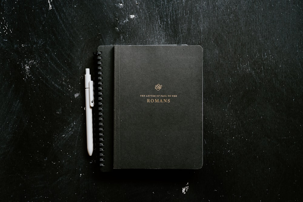 um caderno com uma caneta em cima dele