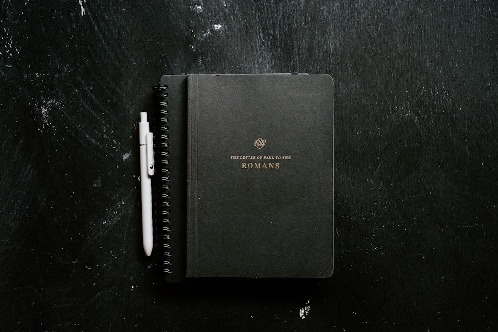 a notebook with a pen on top of it