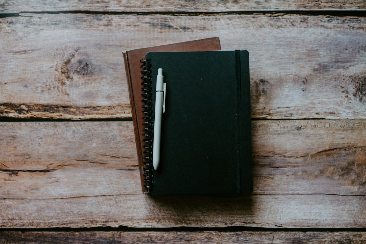 Cuaderno con un bolígrafo encima, preparado para tomar apuntes de estudio