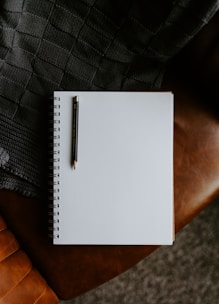 a notebook with a pen on top of it