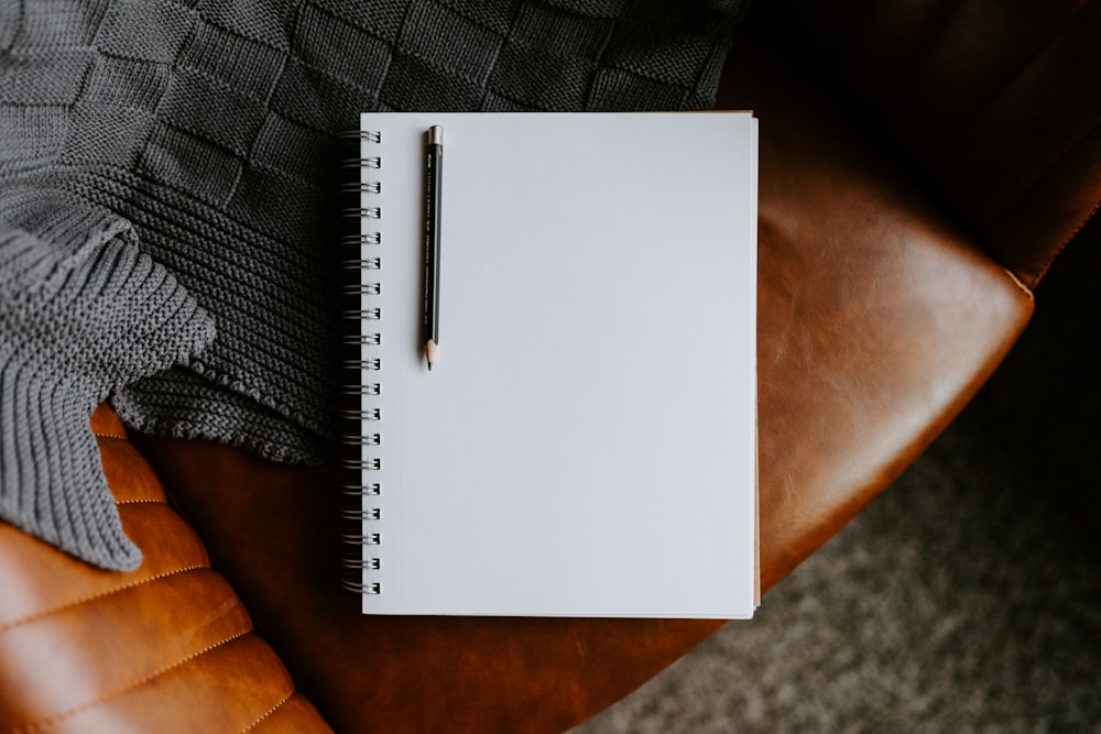 a notepad sitting on top of a brown leather chair