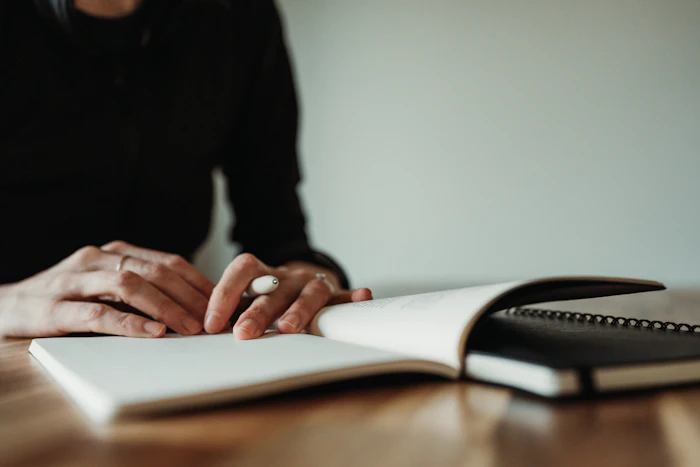 Une personne consulte ses notes à une table