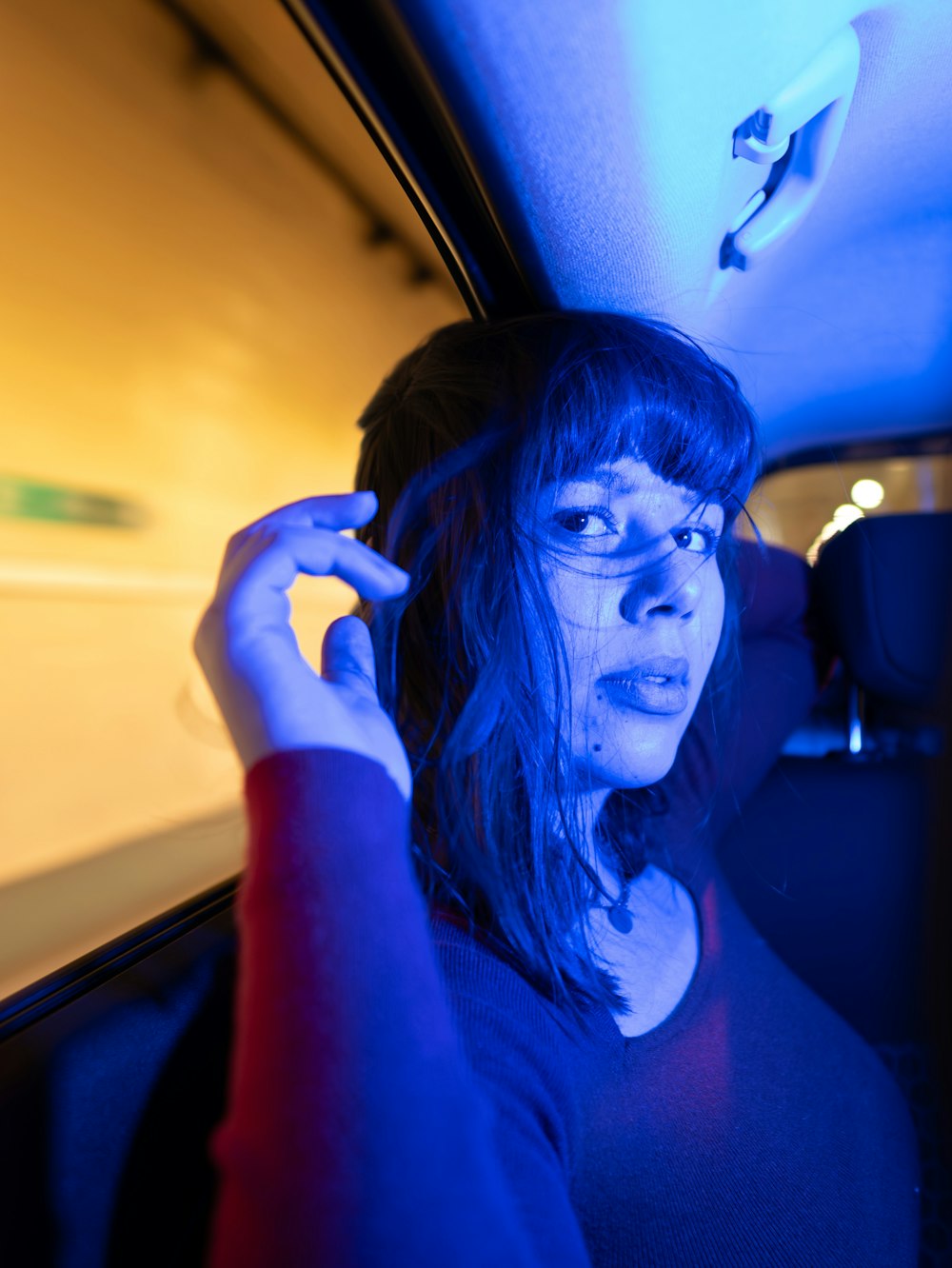 a woman in a car holding a cell phone to her ear