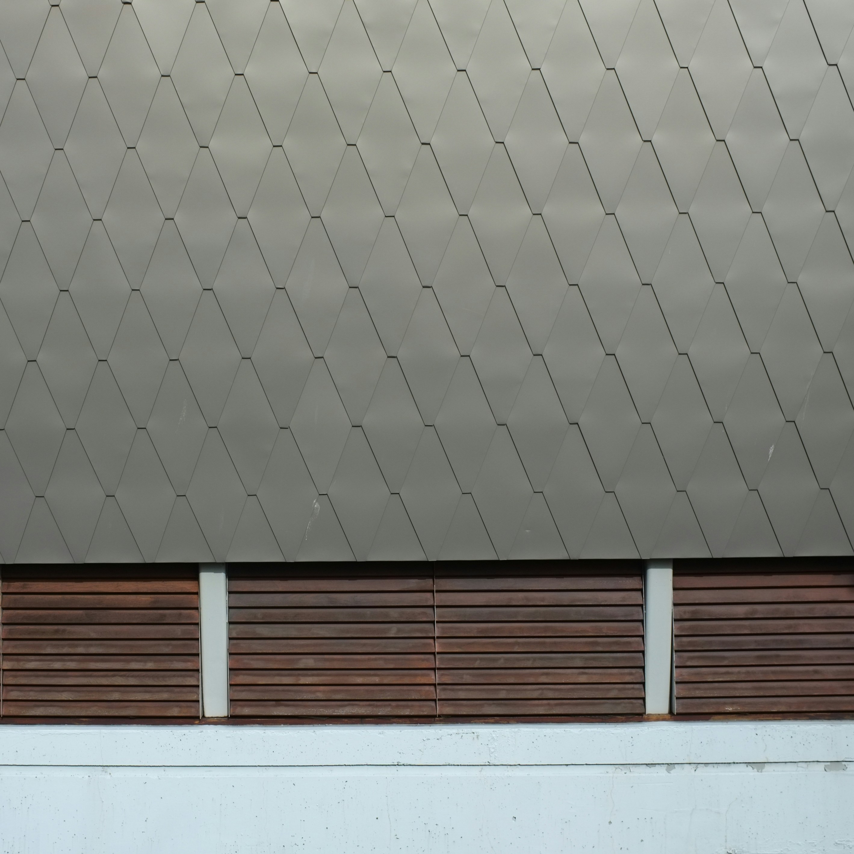 A building with wooden slats on the side of it photo – Free Grey Image ...