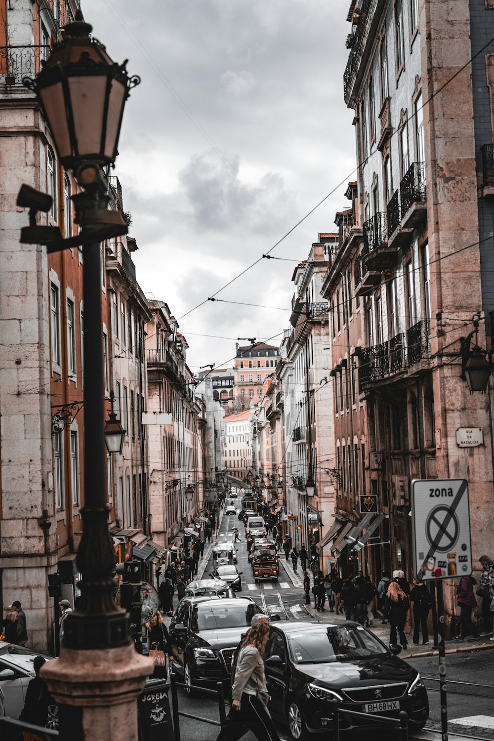 a woman walking down a street next to tall buildings