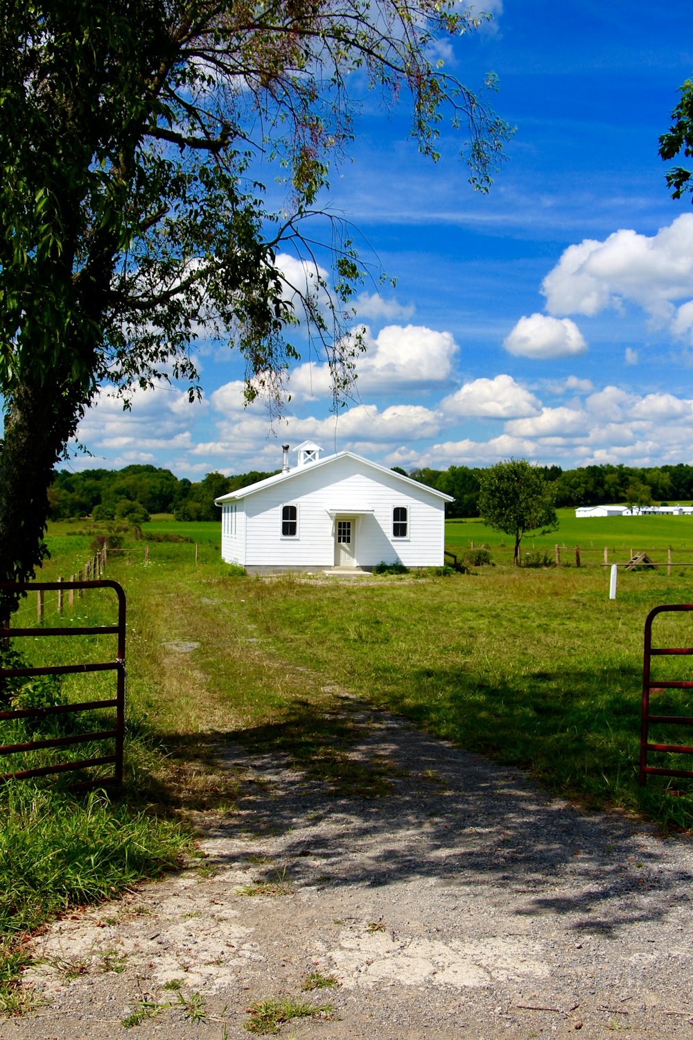 a white house sitting on top of a lush green field