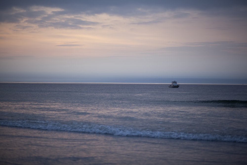 a boat is out in the ocean on a cloudy day