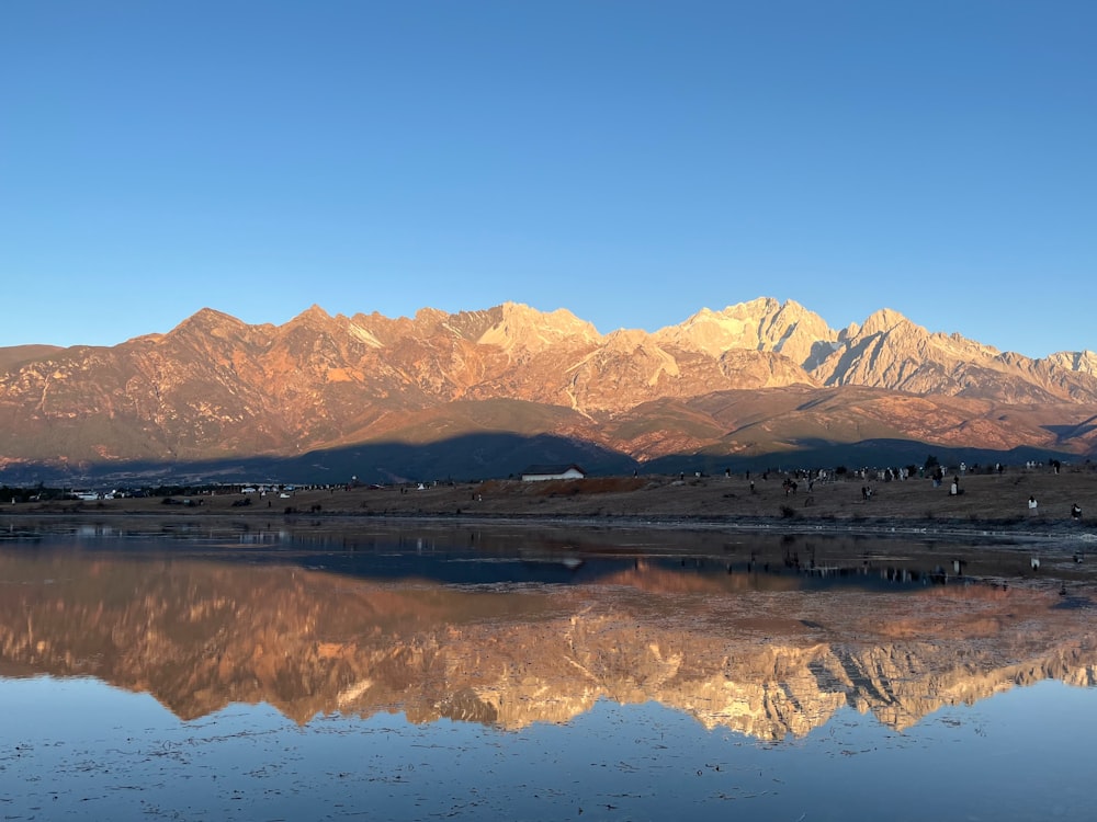 the mountains are reflected in the still water of the lake