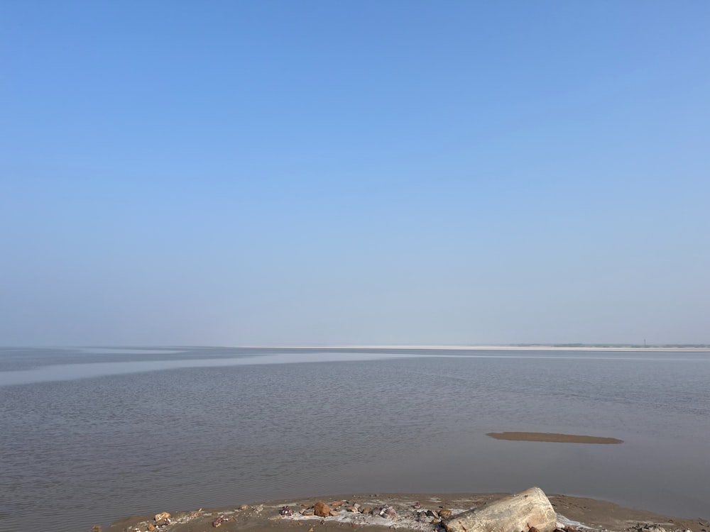 a large body of water sitting under a blue sky