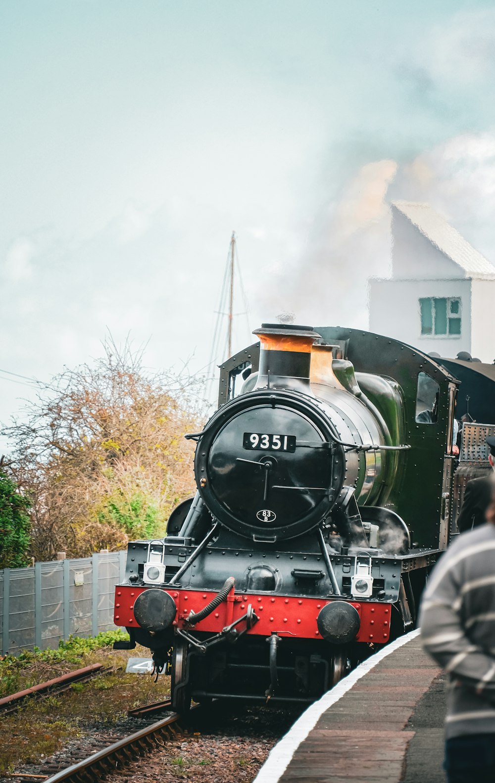 a black and red train traveling down train tracks