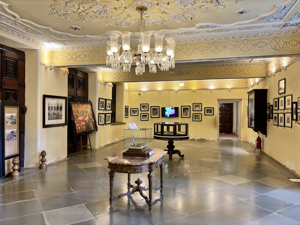 a room with a chandelier and pictures on the walls