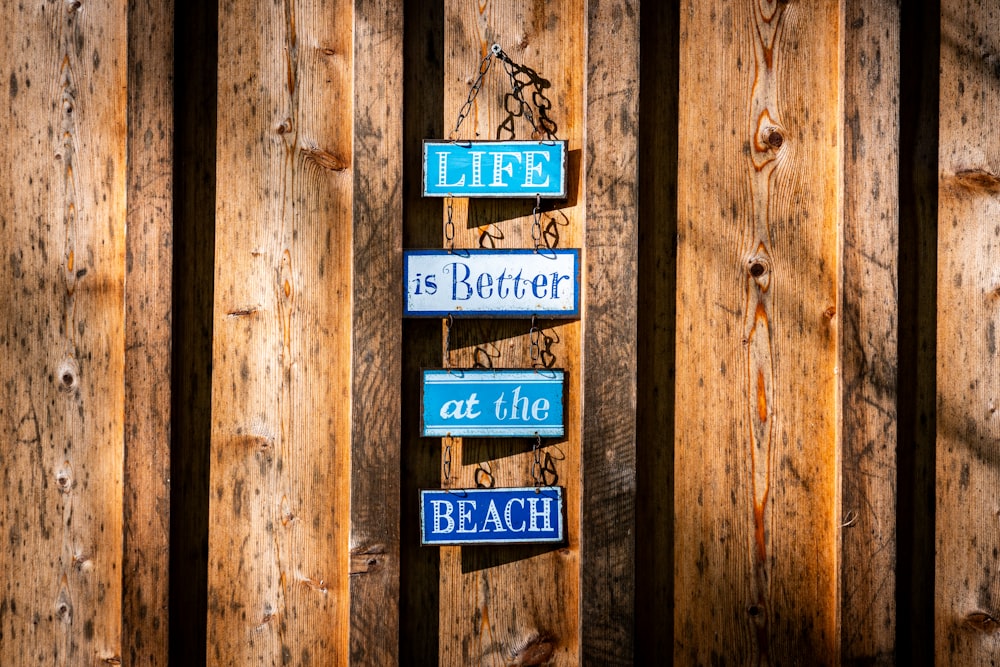 a wooden fence with a sign that says life is better at the beach