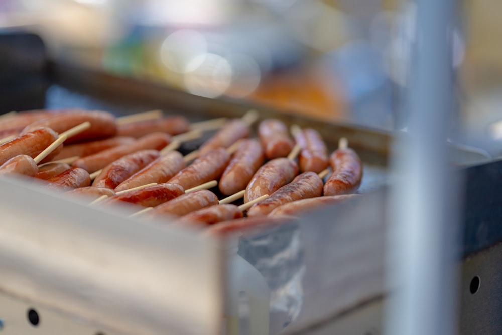 a bunch of sausages are being cooked on a grill