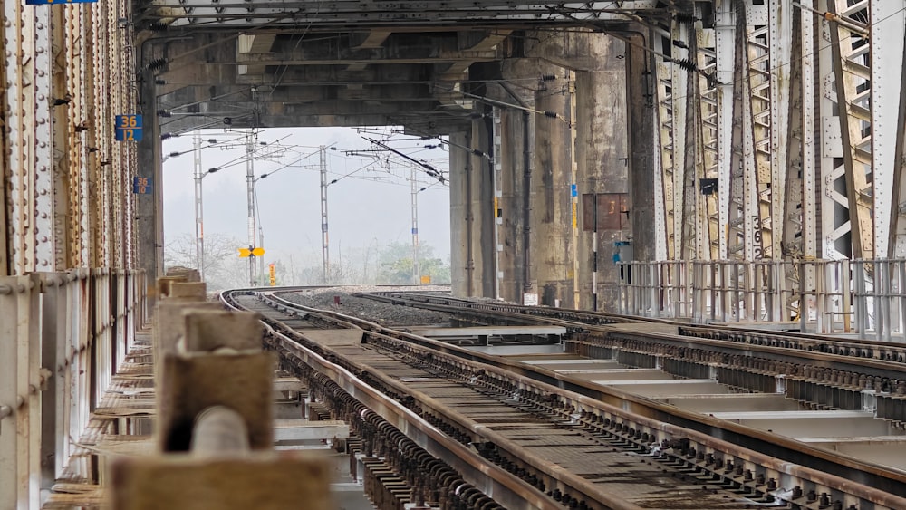 a train traveling down train tracks under a bridge