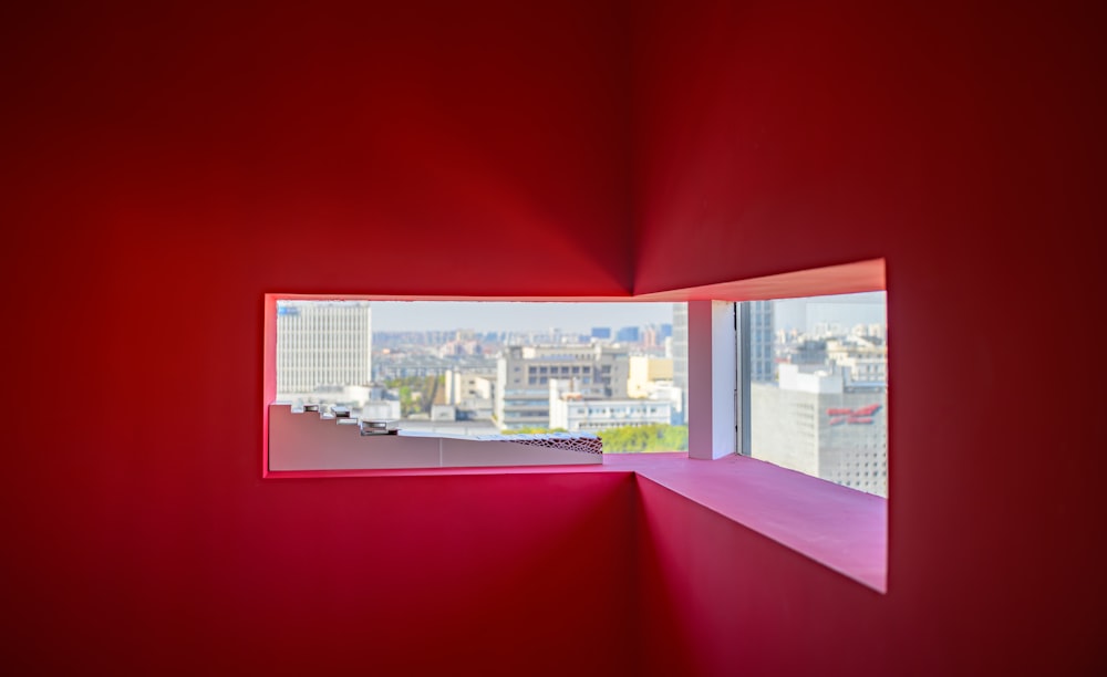 una camera rossa con vista su una città