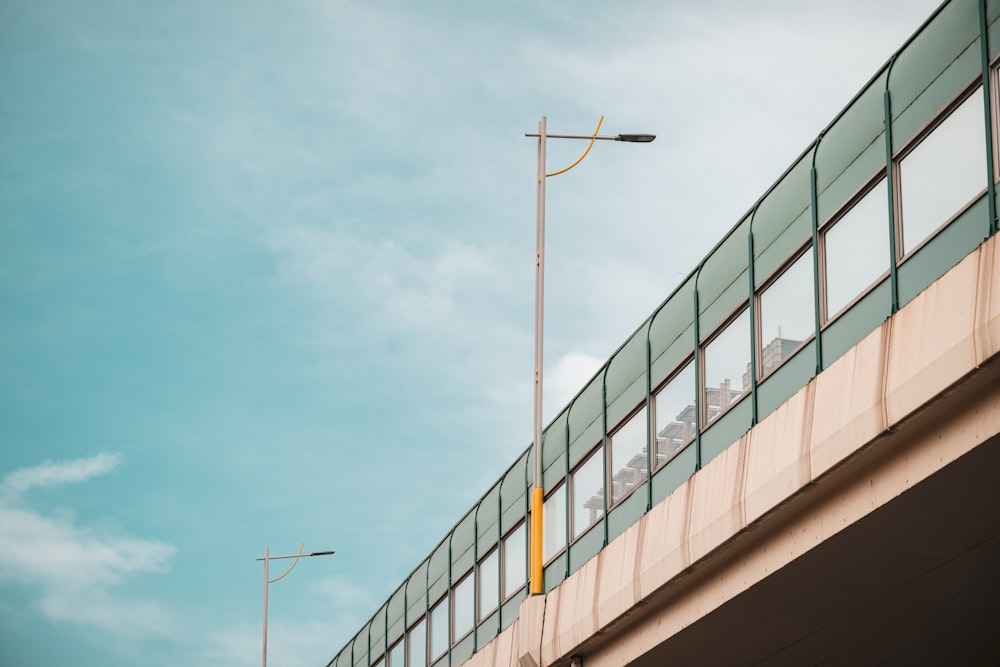 a yellow traffic light sitting on the side of a bridge