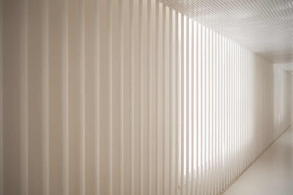 um quarto branco com persianas verticais na parede