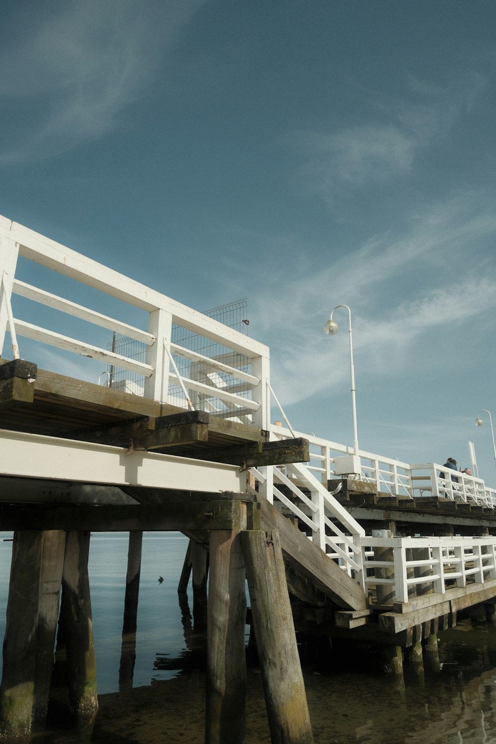 a pier with a white railing and a light pole